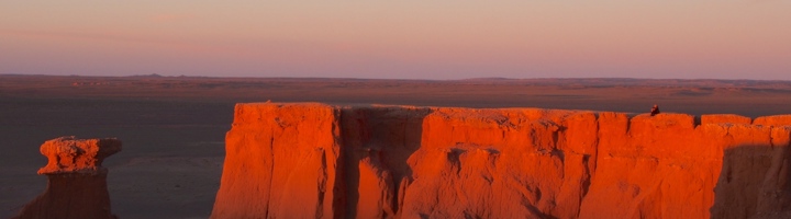 Rode kliffen in de Mongoolse Gobiwoestijn bij zonsondergang.