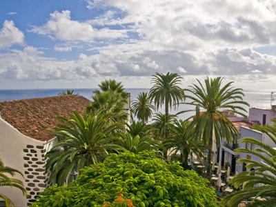 Wit dorp met palmbomen en uitzicht op de Atlantische Oceaan tijdens de wandelvakantie Tenerife & La Palma.