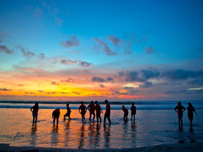 Silhouetten van reizigers op het strand bij zonsondergang op Bali.