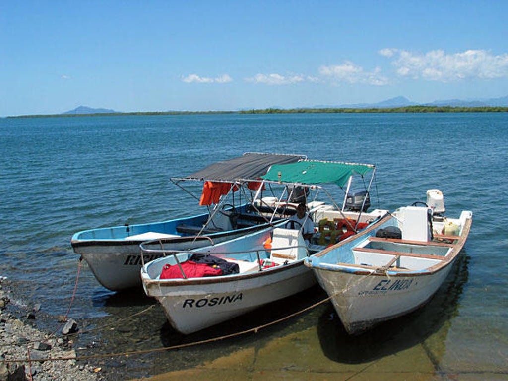 Drie bootjes aan de oever van een lagune in Madagascar tijdens een familiereis.