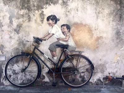 Streetart van twee kinderen op een fiets op een verweerde muur in George Town, Penang, Maleisië.