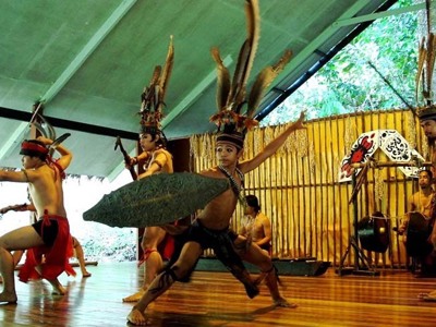 Traditionele dansvoorstelling met kostuums en verenhoofdtooien tijdens de route Maleisisch Borneo Hoogtepunten.