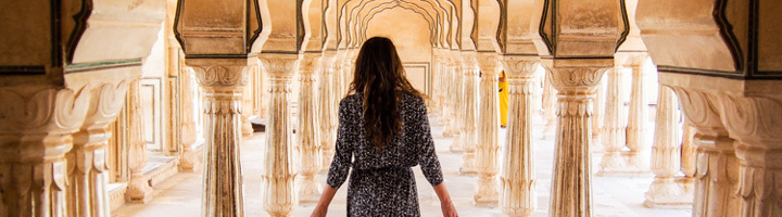 Vrouw loopt door de bogen en zuilengang van Amber Fort in Jaipur.