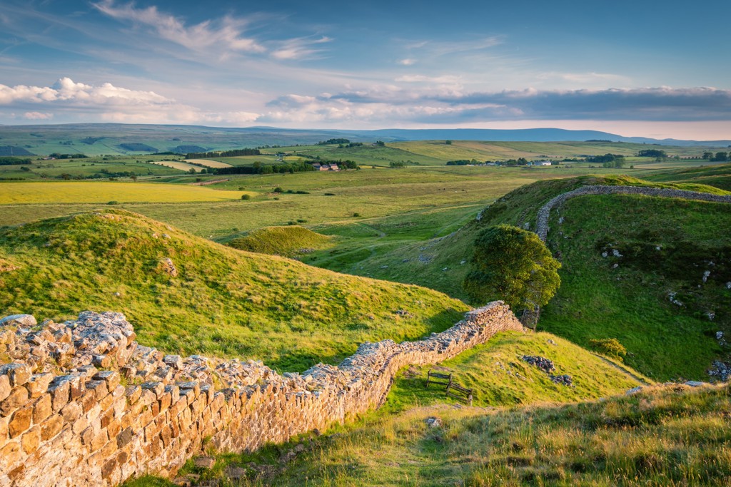 Groene heuvels en wandelpad langs Hadrian’s Wall tijdens een groepsrondreis door het Verenigd Koninkrijk.