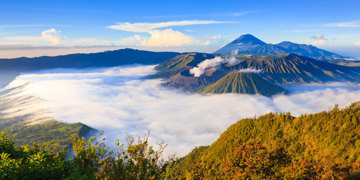 Vulkanlandschap bij zonsopgang op Java, met de Bromo en Semeru boven een zee van wolken.