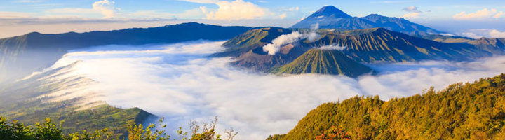 Vulkanlandschap bij zonsopgang op Java, met de Bromo en Semeru boven een zee van wolken.