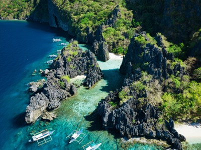 Lagunebaaien met kalkstenen rotsformaties en bootjes bij El Nido, Palawan, tijdens de route Filipijnen.