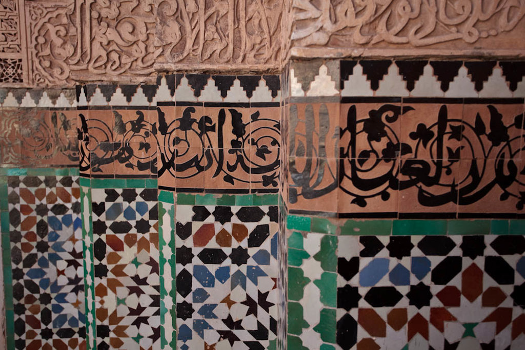 Mozaïektegels en sierlijke kalligrafie op een muur in Andalusië tijdens de rondreis Andalusië.