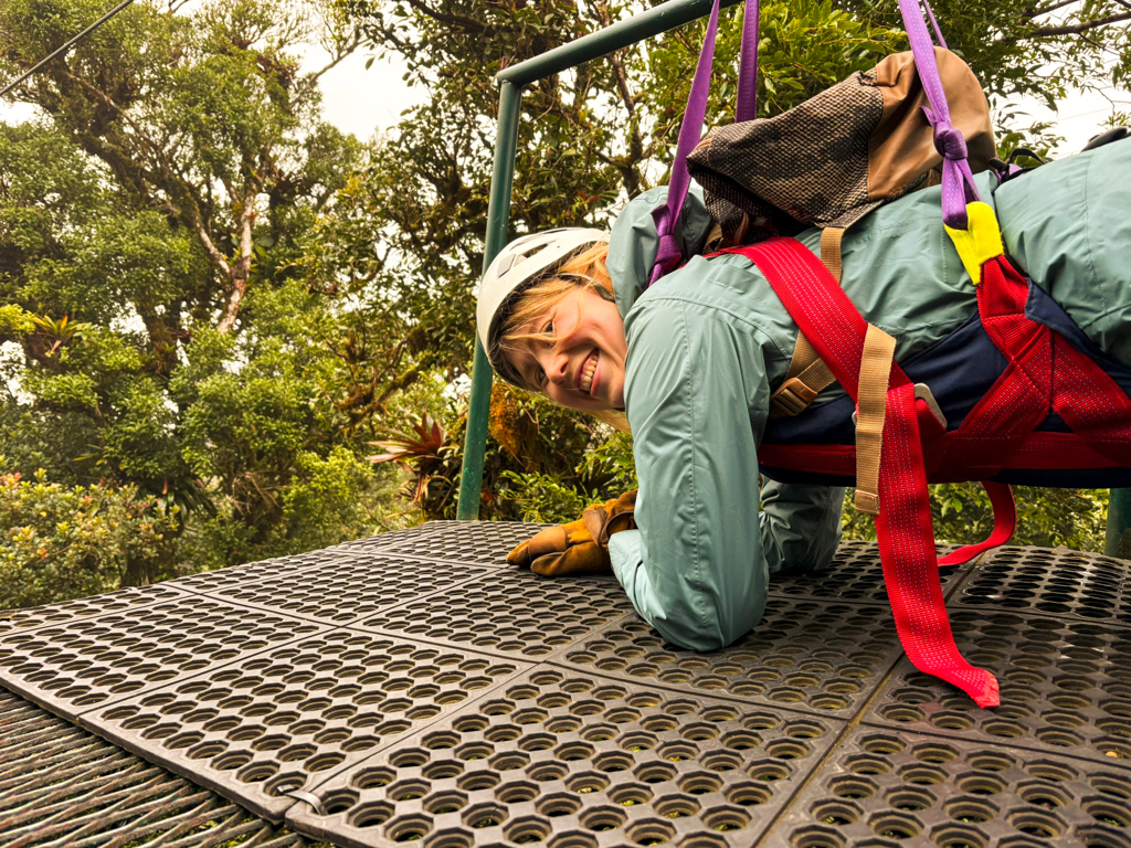 Reiziger met helm en veiligheidsharnas tijdens ziplinen door het regenwoud in Costa Rica.