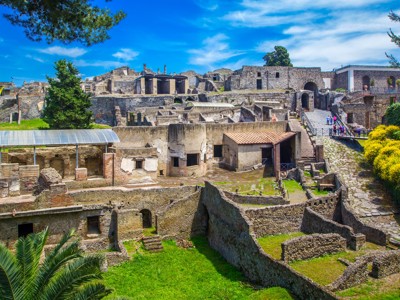 Ruïnes van Pompeï bij de Amalfikust in Italië, met oude stenen gebouwen en wandelpad onder blauwe lucht.