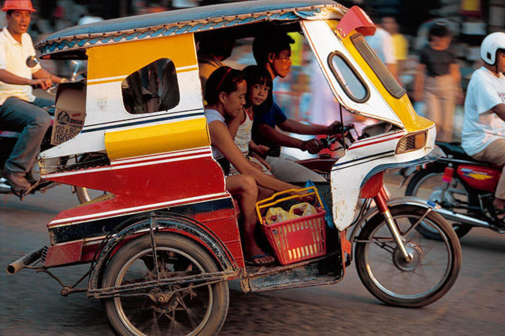 Kleurrijke tricycle met passagiers op straat in de Filipijnen tijdens een groepsrondreis.