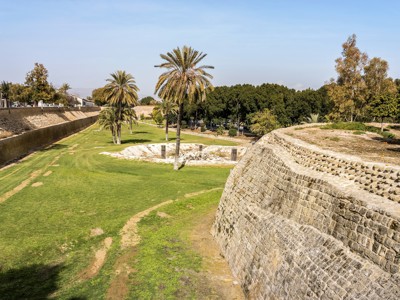 Venetiaanse stadsmuur in Nicosia met palmbomen en groene gracht, Cyprus.