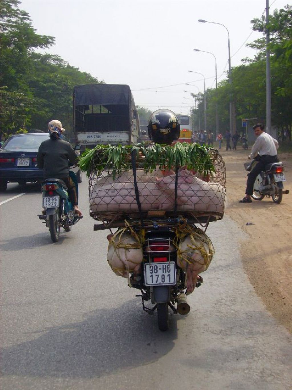Motorfiets met mand vol goederen op een drukke weg in Myanmar tijdens een familiereis.