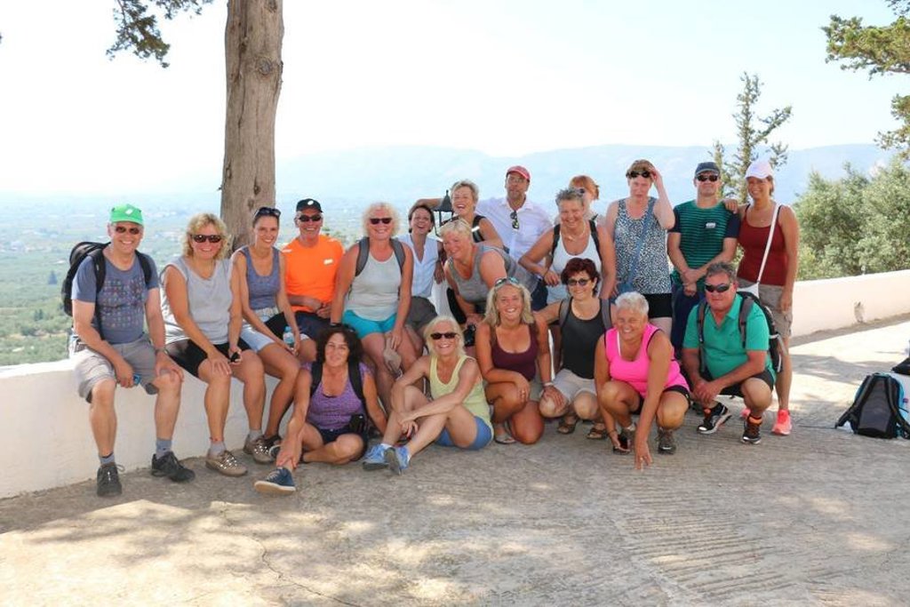 Wandelaars op een bergpad op Evia, Griekenland, met uitzicht op groene bergen en dorpen.