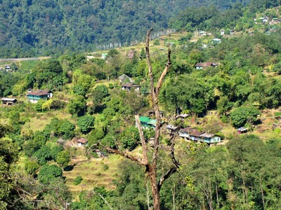 Groen berglandschap met verspreide dorpjes langs de Route Sikkim en Bhutan.