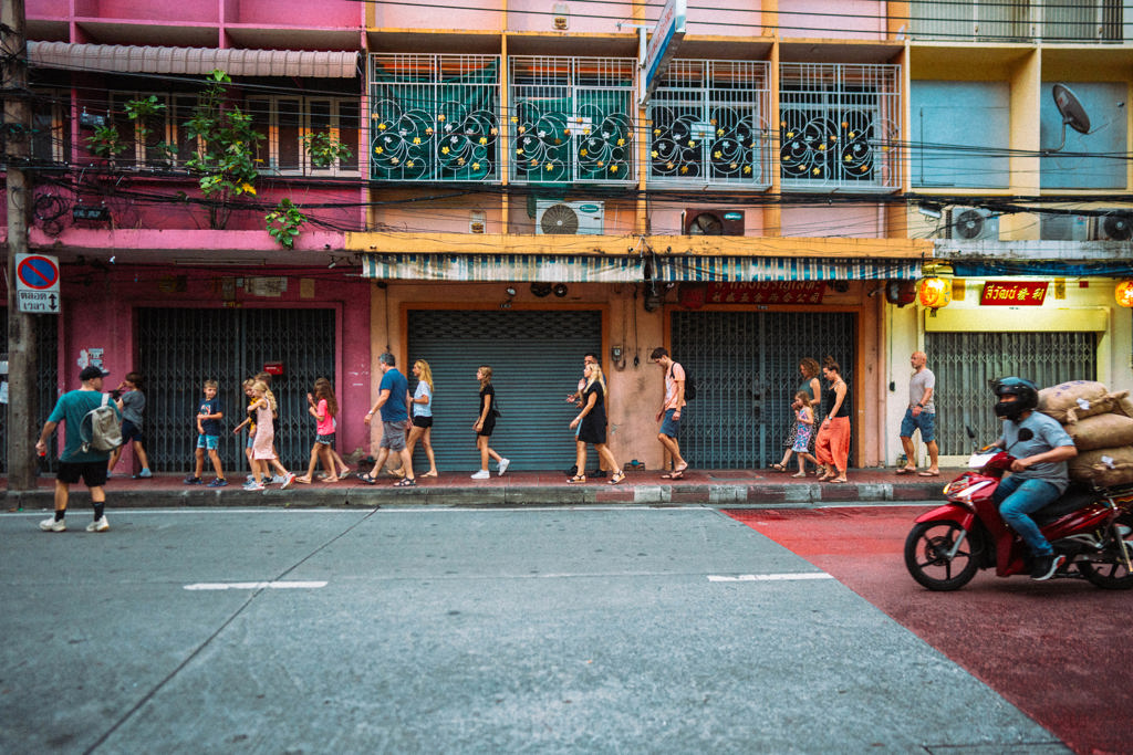 Gezinnen wandelen door een kleurrijke straat in Bangkok tijdens een familiereis Thailand, Laos en Cambodja.
