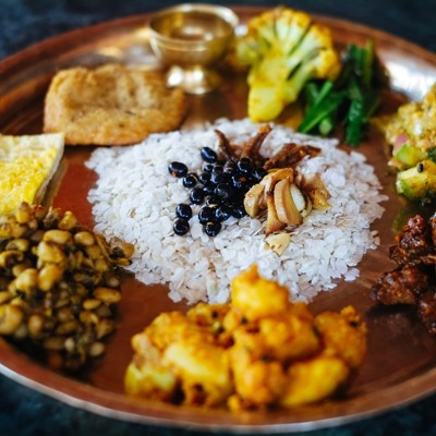 Nepalese thali met rijst, linzen en diverse groentecurry’s op een metalen bord.