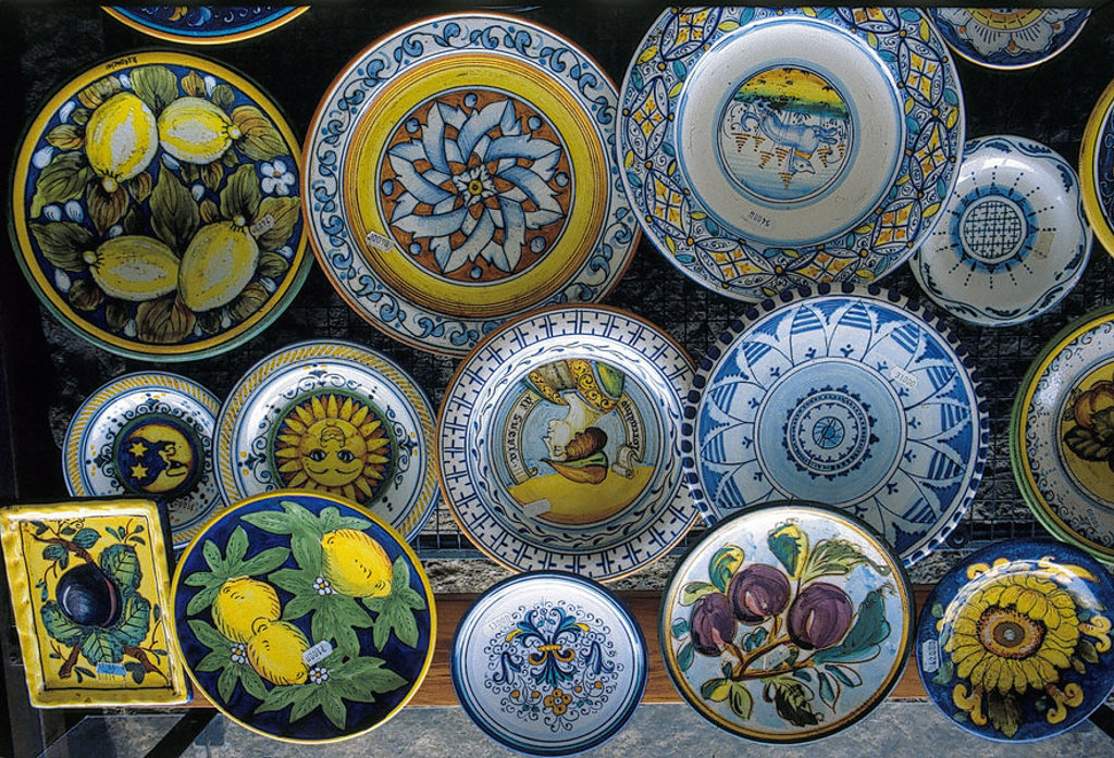 Kleurrijk Toscaans keramiek met handbeschilderde borden en schalen, te zien tijdens een fietsvakantie in Toscane.