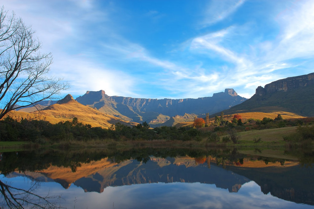 Drakensbergen in Lesotho met bergtoppen en weerspiegeling in een rustig meer.