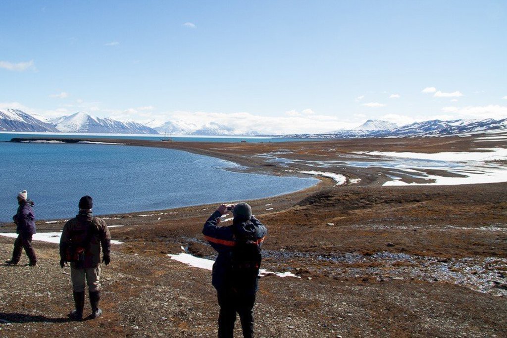 Zeilschip de Antigua tijdens groepsrondreis bij Spitsbergen, met bergen en zee op de achtergrond.