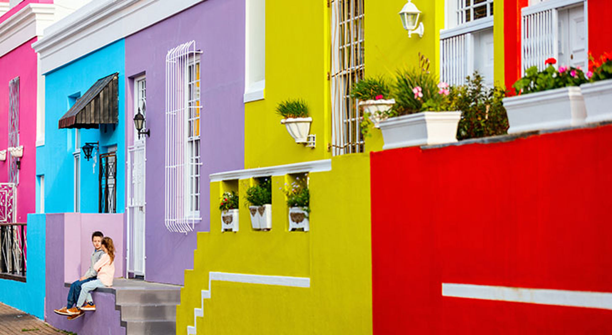 Kleurrijke gevels met trappen en bloembakken in de Bo-Kaap, Kaapstad.