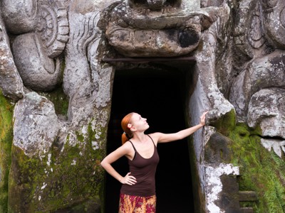 Vrouw bij de ingang van de Olifantengrot Goa Gajah in Ubud, Bali.