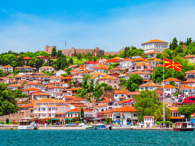 Uitzicht op Ohrid met rode daken, het fort op de heuvel en de vlag van Noord-Macedonië aan het meer.