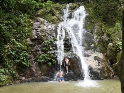 Reizigers bij een waterval in het regenwoud tijdens de Route Colombia.