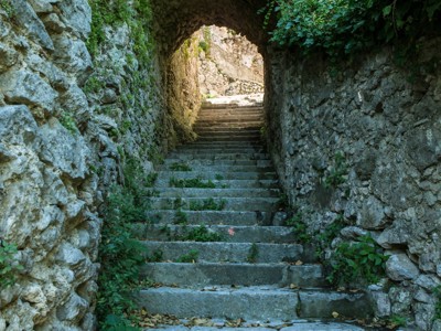 Stenen trap door een oude boogtunnel langs een wandelpad aan de Amalfikust, Italië.