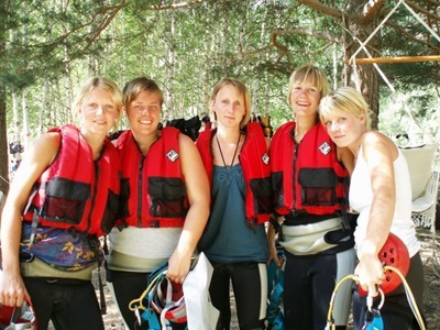 Groep reizigers met reddingsvesten en wetsuits klaar voor wildwaterraften in Nationaal Park Écrins, Frankrijk.