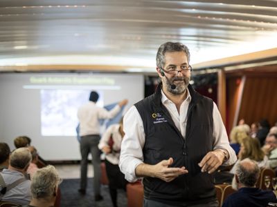 Expeditieleider geeft briefing aan reizigers aan boord tijdens route Canada en Groenland, 18 dagen.