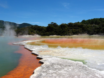 Stomende geothermische bron met oranje en groene kleuren bij Rotorua, Nieuw-Zeeland.