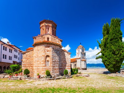 Kerk van Sint-Johannes bij het Meer van Ohrid in Noord-Macedonië, met kloostergebouwen en cipres.