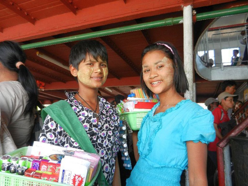 Twee jonge verkopers met thanaka op hun gezicht op een boot in Myanmar.