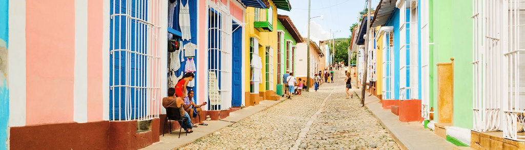 Kleurrijke straat met kinderkopjes en historische huizen in Cuba, tijdens de familiereis Cuba Hoogtepunten.