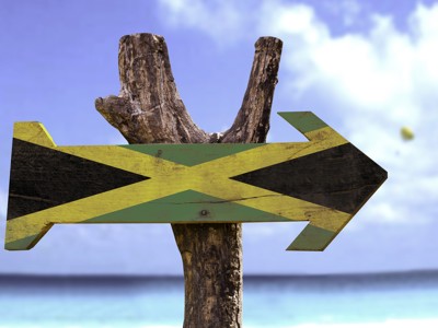 Houten wegwijzer in de kleuren van de Jamaicaanse vlag aan zee, Route Jamaica 16 dagen dag 14.