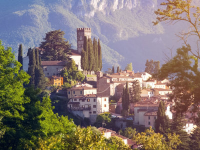 Heuveldorp in Toscane met cipressen en kerk, in warm avondlicht.