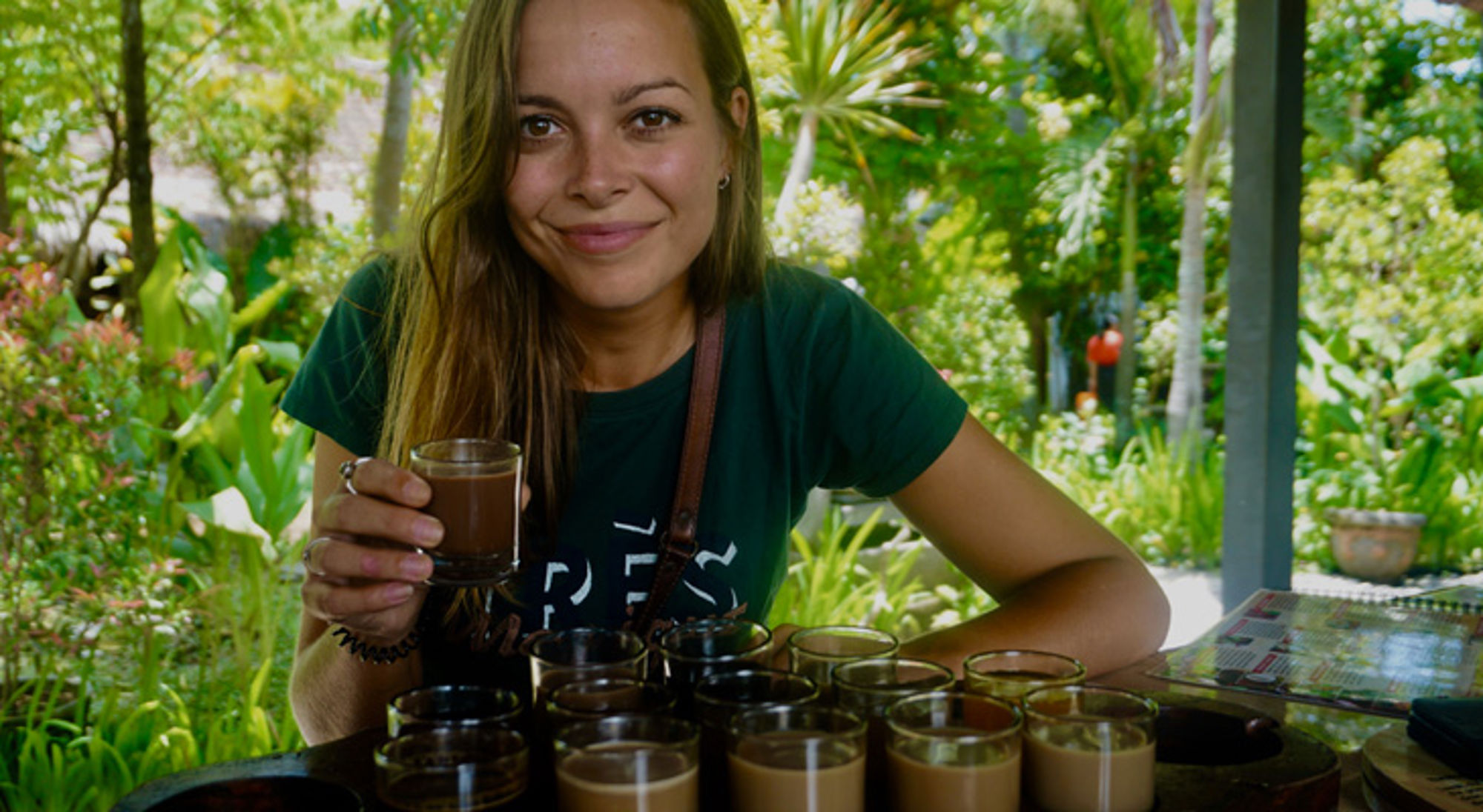 Vrouw proeft lokale koffie tijdens een koffietasting in een tropische tuin.