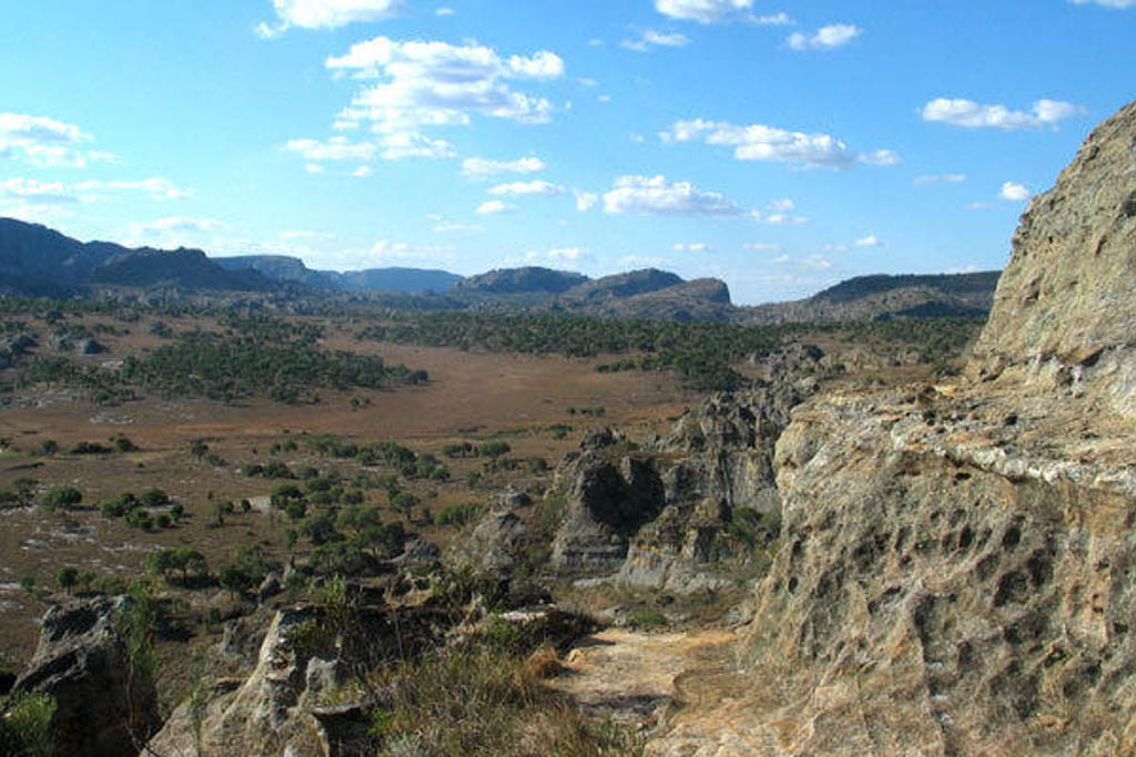 Rotsachtig landschap met uitgestrekte vlakte en heuvels onder een blauwe lucht tijdens een familiereis Madagascar.