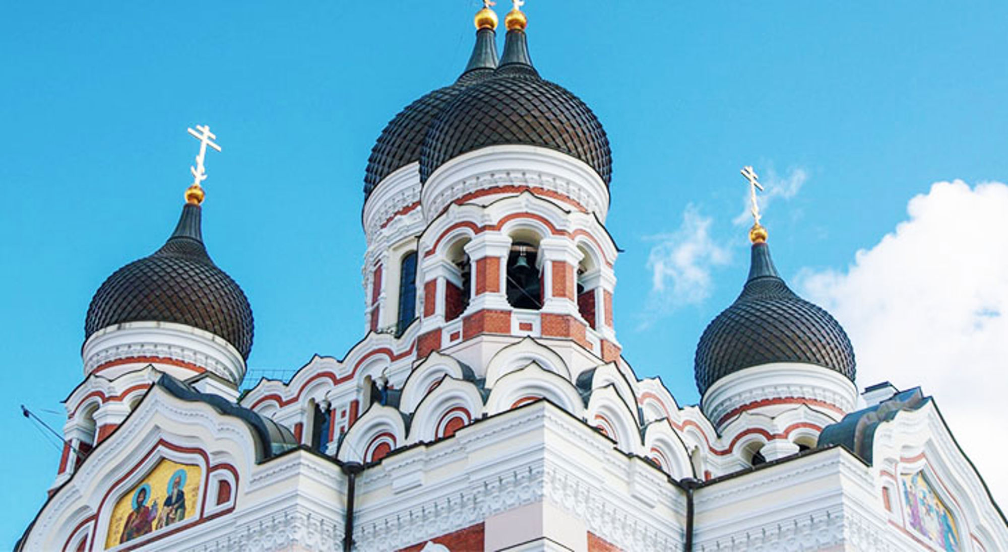 Koepels van de Alexander Nevski-kathedraal in Tallinn tegen een heldere blauwe lucht.
