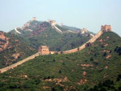 De Chinese Muur kronkelt over groene heuvels tijdens de 17-daagse route door China.