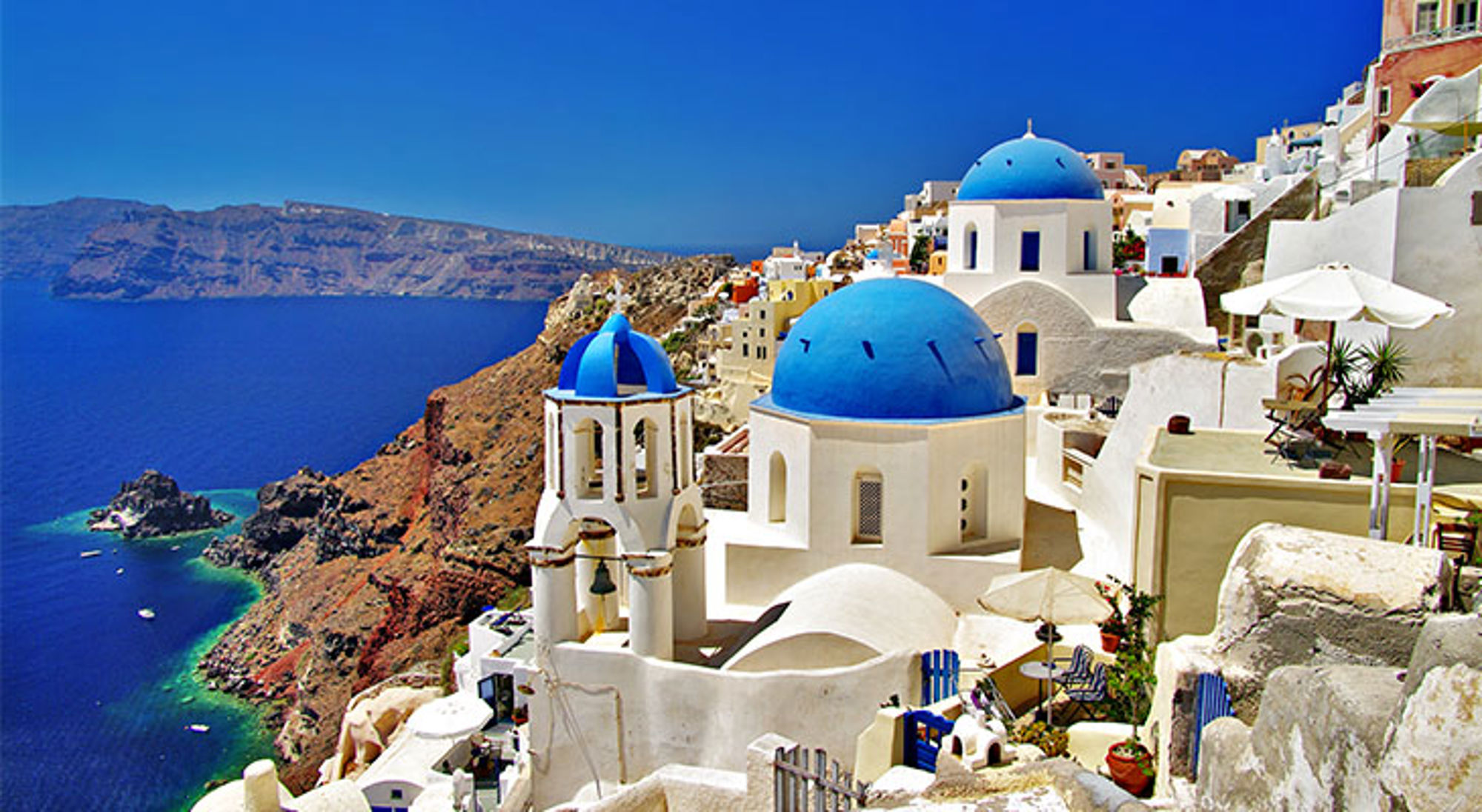 Santorini Witte huizen en blauwe koepelkerken op de kliffen van Santorini met uitzicht op de Egeïsche Zee.
