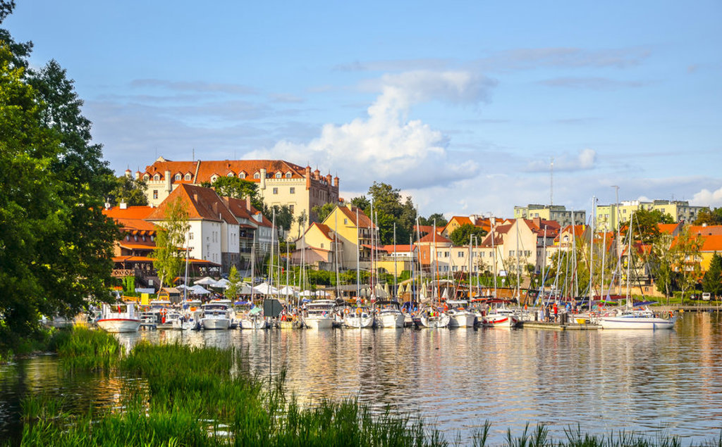 Jachthaven met zeilboten en kleurrijke huizen aan het water in Polen.
