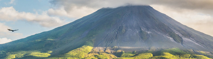 Arenal vulkaan bij La Fortuna in Costa Rica, met groene hellingen onder een wolkenlucht.