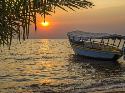Houten boot bij zonsondergang aan de kust in Kenia & Tanzania-route.