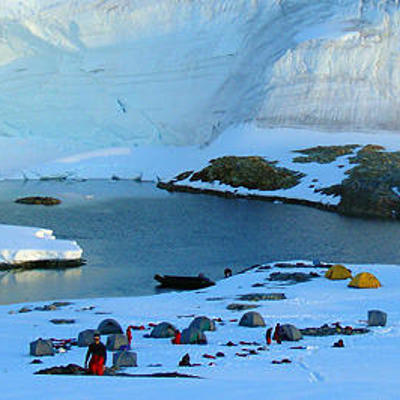 Kampeerplek met tenten aan een ijzige baai in Antarctica, tijdens de expeditie Crossing the Circle voorbij de Zuidpoolcirkel.
