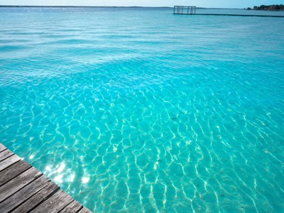 Turquoise zeewater met houten steiger, Route Ruta Maya.