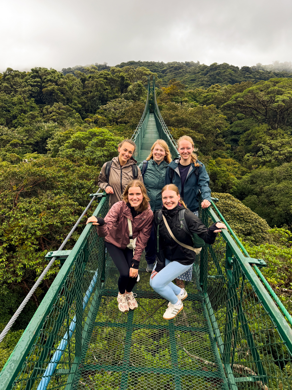 Vijf reizigers op een hangbrug boven het nevelwoud tijdens een 22-35ers reis Costa Rica.