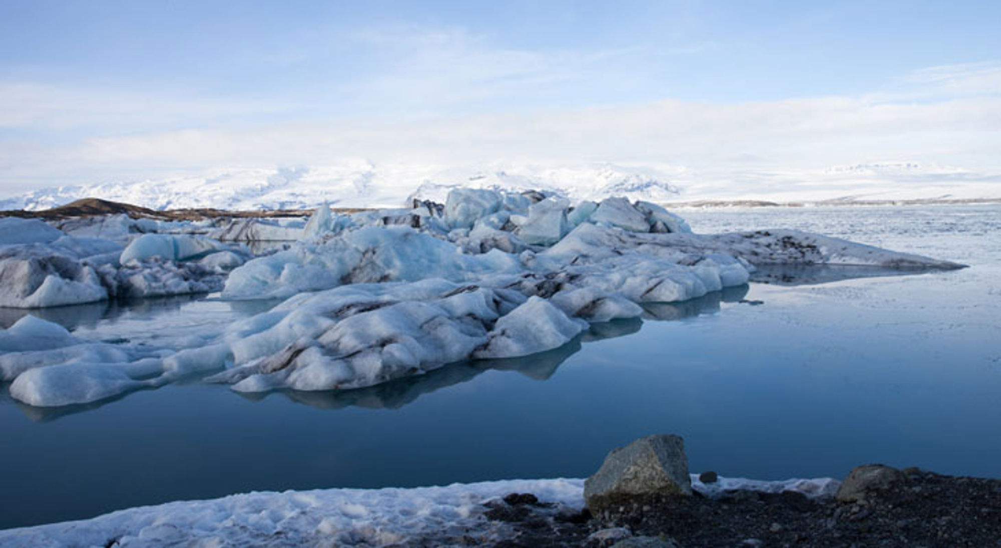 Jökulsárlón gletsjerlagune IJsland Drijvende ijsbergen in de gletsjerlagune Jökulsárlón in IJsland, met besneeuwde bergen op de achtergrond.