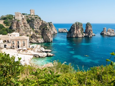 Kust bij Scopello in West-Sicilië met rotsformaties, turquoise zee en oude tonnara aan de baai.